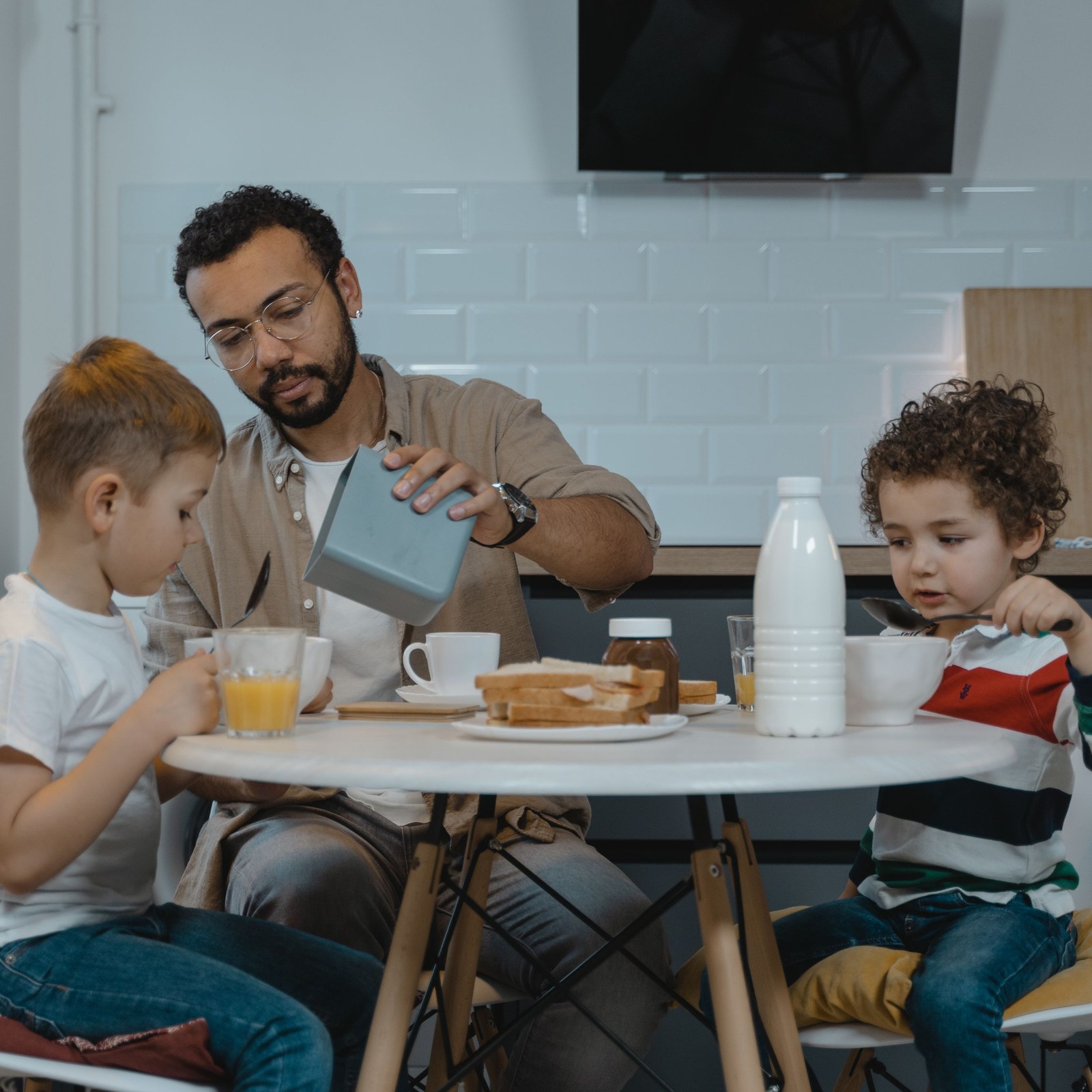 Famiglia a colazione con una bottiglia di latte